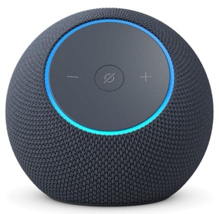 Round dark-gray smart speaker with a blue ring and + / - controls on top, showing a mute button in the center (Alexa device)