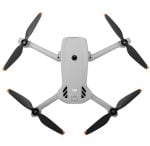 Top-down view of a white DJI quadcopter drone with four propellers extended outward from a central body, ready for flight.