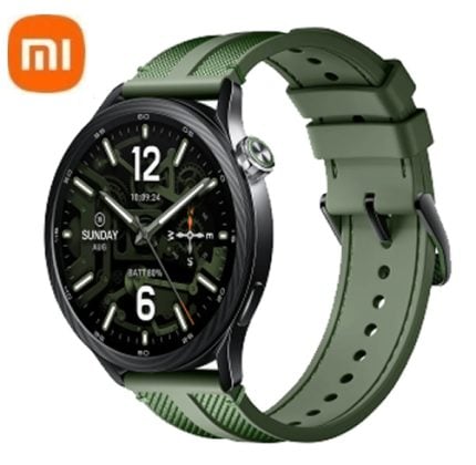 Round black smartwatch with green strap, displaying time and date on the watch face; orange Mi logo in the top-left corner.
