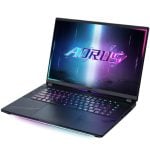 Gaming laptop open with rainbow RGB keyboard lighting and AORUS logo on screenbed display.