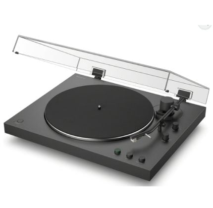 Black turntable on a gray base with a raised clear dust cover, tonearm on the right and front controls visible for playback and operation.