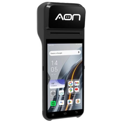 Rugged handheld Android device in a black dock labeled 'AON' with home screen showing apps like Google and YouTube.
