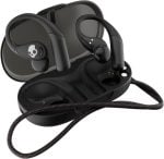 Black wireless earbuds in an open charging case with a braided cable; Skullcandy logo visible on one earbud.