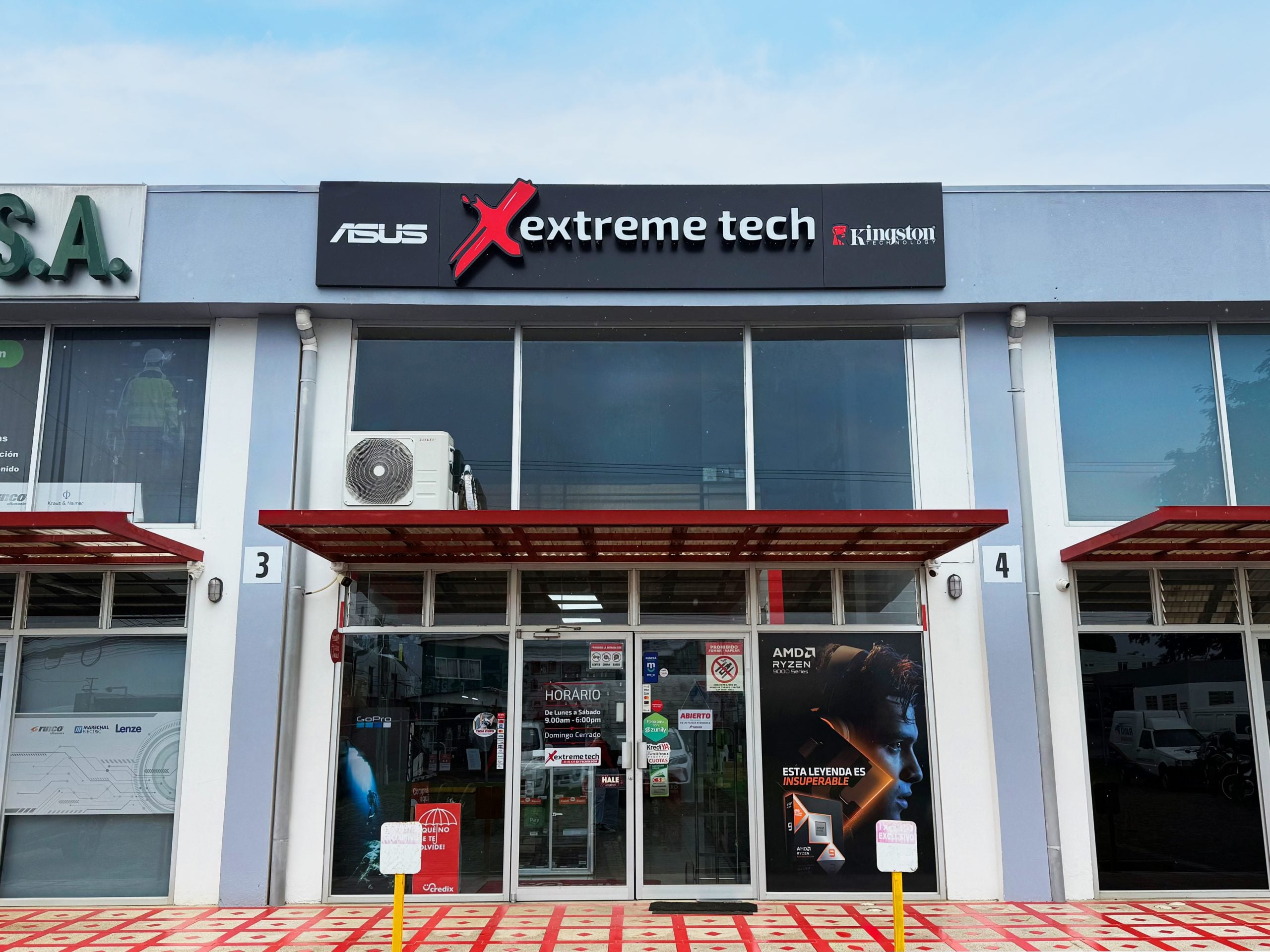 Storefront signage reading 'ASUS Extreme Tech' with a red X logo and Kingston Technology panel above glass doors and windows.